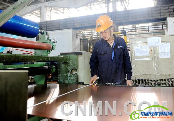 图为洛铜铜板带厂员工在测量新能源汽车用铜带材。汪恒玉摄_副本